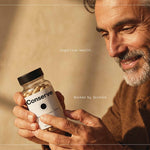 Man holding Conserve bottle Alt text: Man in his 50s holding Conserve cognitive resilience formula bottle for memory and focus support.