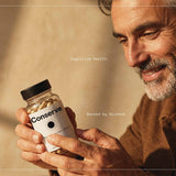 Man holding Conserve bottle Alt text: Man in his 50s holding Conserve cognitive resilience formula bottle for memory and focus support.