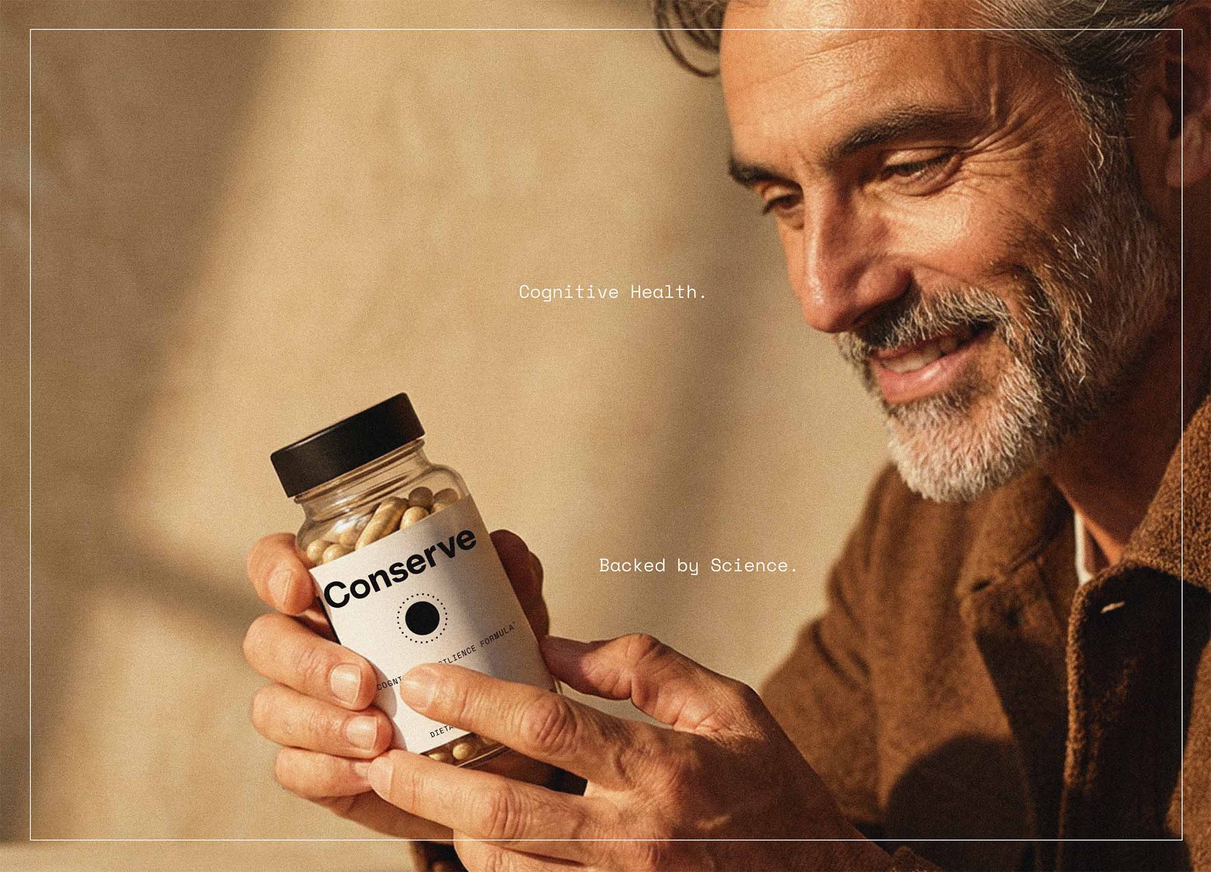 Man holding Conserve bottle Alt text: Man in his 50s holding Conserve cognitive resilience formula bottle for memory and focus support.